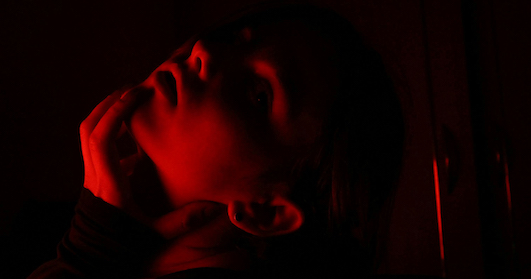 A shadow of a lady touching her face