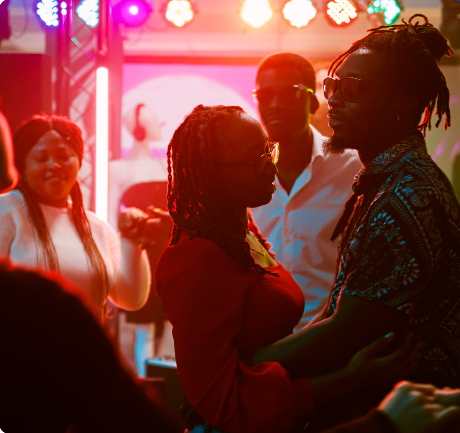 Two people standing in a group dancing and holding each other