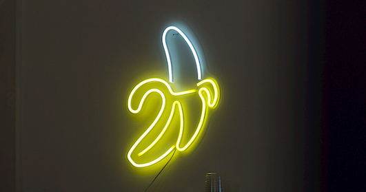 A neon sign of a banana on a wall