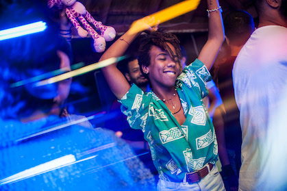 A young black man with dreadlocks dancing in the club